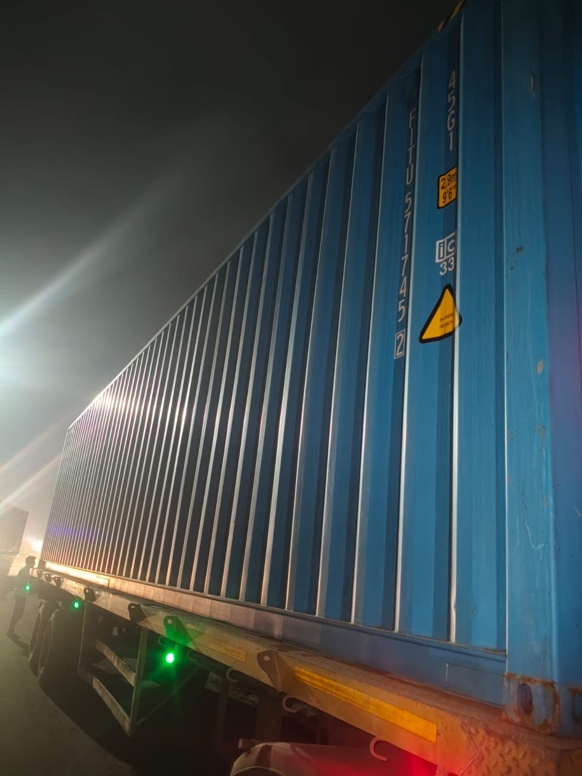 Loaded shipping container on a chassis during a night inspection