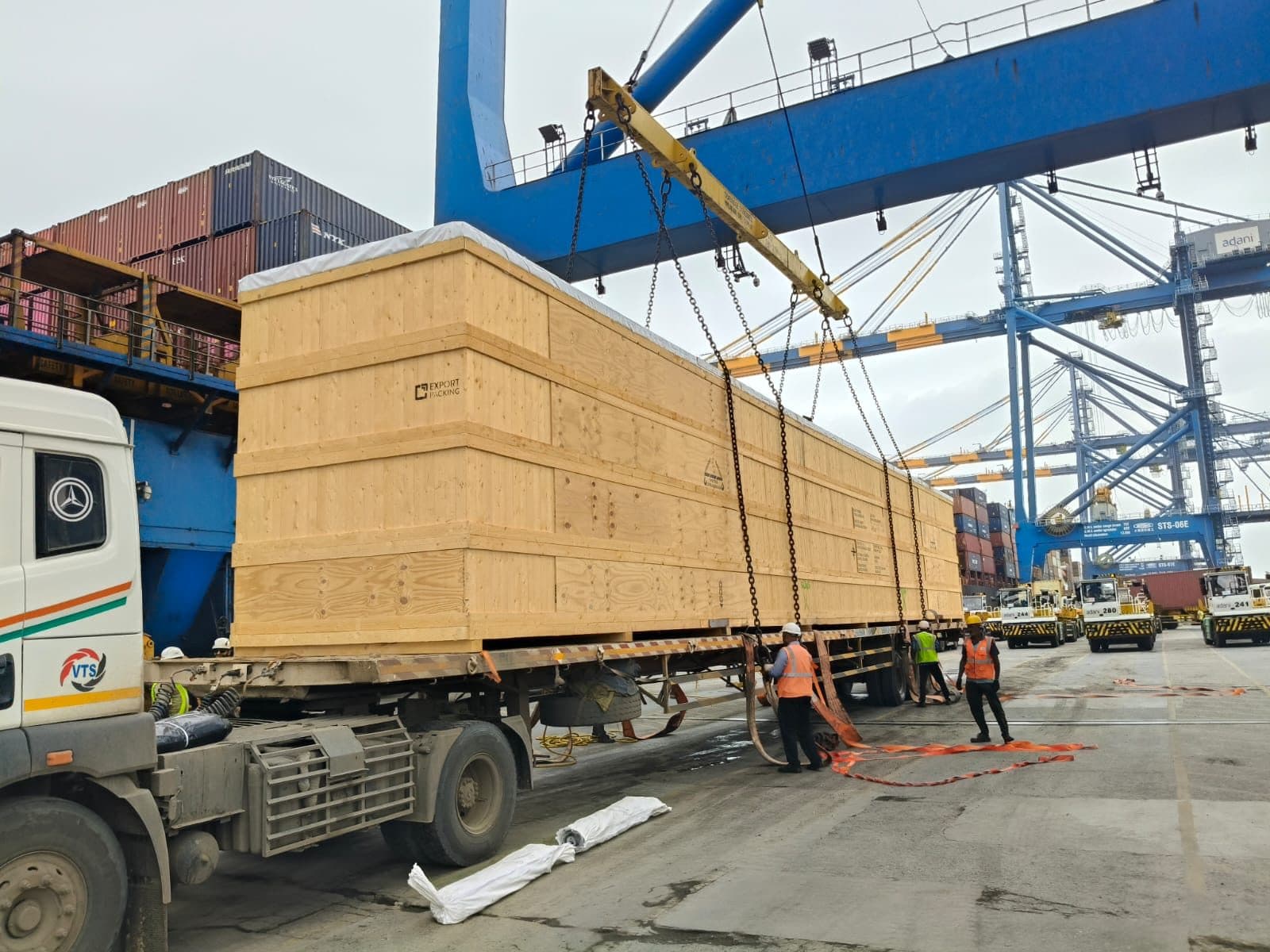 Breakbulk cargo on a trailer under port cranes during loading attendance